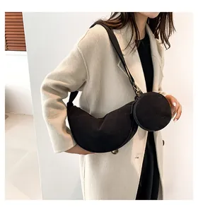 Detail of black corduroy crescent bag and mini round pouch on a fashion model