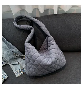 Detail of grey corduroy tote bag featuring diamond quilting and curved zipper closure