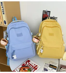 Detail of blue and yellow school backpacks with cute charms and waterproof nylon fabric