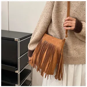 Détail du sac à bandoulière marron à franges avec texture daim et détails bohèmes