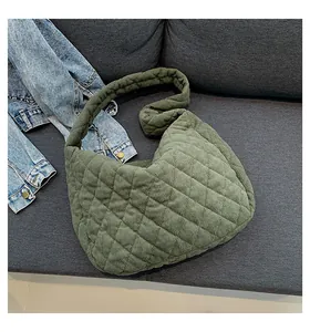 Detail of dark green corduroy tote bag featuring large quilted diamond patterns