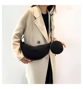 Model wearing black corduroy crescent bag with matching small round coin purse