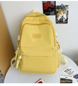Detail of yellow minimalist student backpack with HAQHIYQ brand logo and side buckles
