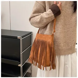 Détail du sac bandoulière marron à franges avec texture suédée et boucle dorée