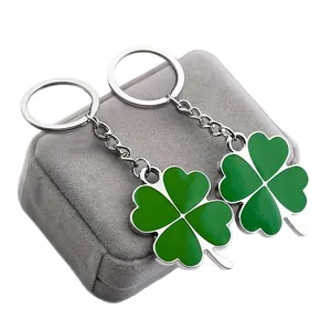 Set of two stainless steel four-leaf clover keychains with green enamel on a display box