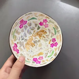 Detail of natural coconut bowl featuring inlaid mother of pearl and painted elephant design