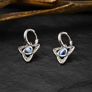 Detailed shot of Celtic knot earrings with blue cat eye stone on black textured stone