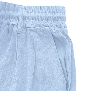 Detail of light blue linen trousers showing elastic waistband, belt loops and side pockets
