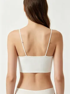 Detailed back view of white ribbed lingerie top with adjustable straps and wavy trim