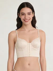 Detailed close-up of cream satin corset bralette with lace trim and front hook closure