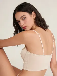 Close-up of minimalist beige longline bra with thin straps and wavy knit bottom edge