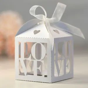 Detail of white laser-cut LOVE candy box with heart cutout and ribbon bow closure