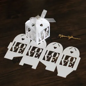 Macro detail of laser-cut ivory LOVE wedding candy box with elegant white chiffon ribbon