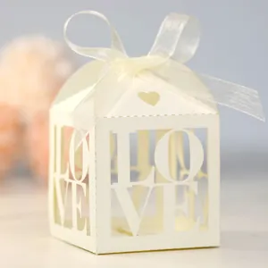 Detail of ivory laser-cut gift box with hollow LOVE design and white organza ribbon