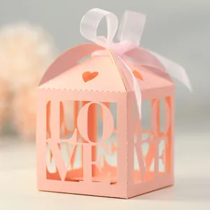 Detail of pink hollow-out LOVE candy box with heart pattern and elegant silk ribbon bow