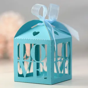 Close-up of bright blue laser-cut candy box with LOVE text and silk ribbon bow