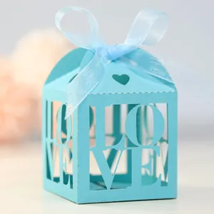 Close-up of light blue laser-cut LOVE gift box with elegant ribbon bow for wedding favors