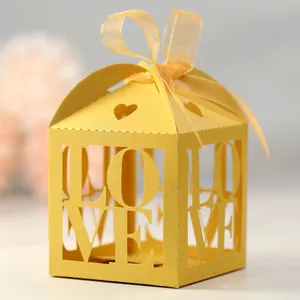 Detail of ivory LOVE hollowed-out candy box with silk ribbon bow for wedding favor