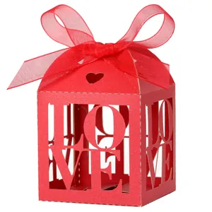 Detail of red hollowed 'LOVE' wedding candy box with a delicate red satin ribbon bow