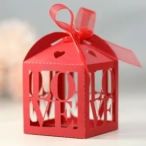 Detail of red laser-cut candy box with LOVE hollow design and elegant ribbon bow