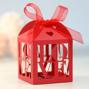 Close-up of red wedding candy box with hollow LOVE letters and a satin ribbon bow