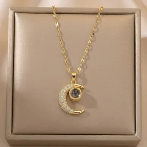 Detail of gold crescent moon pendant with micro-set zircon and love projection stone