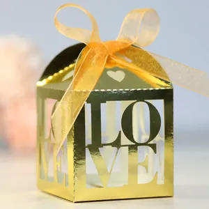Detail of gold mirror hollow LOVE wedding candy box with elegant ribbon and heart cutout