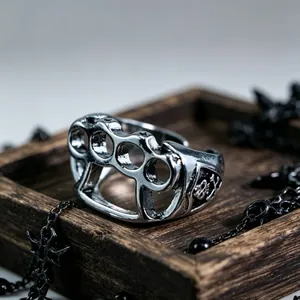 Detail showing vintage silver four-finger knuckle ring with gothic skull relief patterns