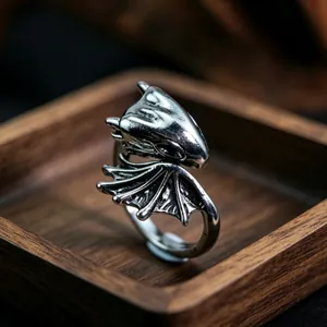 Detailed close-up of a vintage dragon totem ring with adjustable band on wood tray