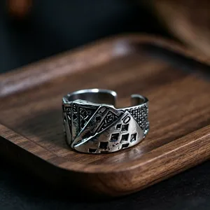 Macro shot of retro metal poker card relief ring featuring intricate woven side textures