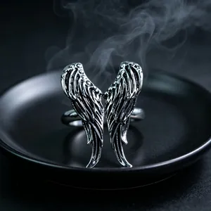 Macro shot of vintage silver metal wings ring with antique finish on black plate
