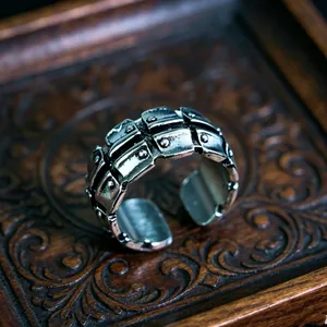Detailed shot of retro punk metal ring with armor texture on vintage wood tray
