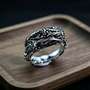 Macro shot of vintage metal ring with intricate organic textures on a wooden base