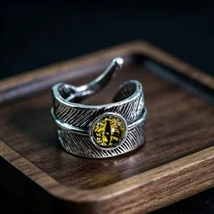Macro detail of retro feather textured ring with a yellow dragon eye gemstone