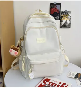 Detail of off-white nylon backpack with adjustable straps and cute plush rabbit charms