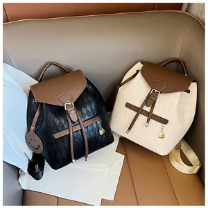 Close-up of quilted bucket backpacks in black and beige with brown leather flip covers