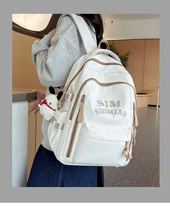 Side view of beige nylon backpack with SJM SIJIMIAO embroidery and a cute puppy plush charm