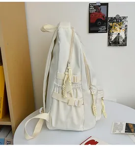 Detail of cream backpack showing side buckle strap and water bottle pocket with mesh