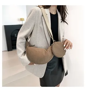 Model wearing a khaki corduroy crescent crossbody bag with matching round coin pouch set