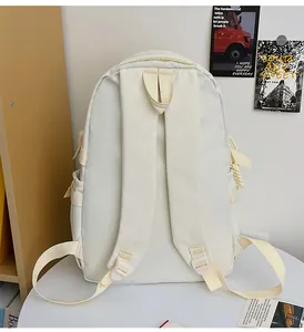 Rear view of cream-white backpack showing padded shoulder straps and side pocket detail