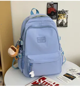Detail of light blue minimalist backpack with cute bear and rabbit charms and side buckle