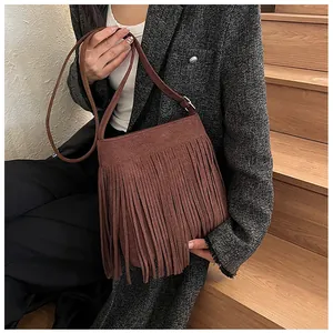 Détail du sac seau bohème en daim marron foncé orné de longues franges verticales
