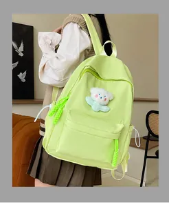 Détail du sac à dos en nylon vert citron avec un joli pendentif ours en peluche