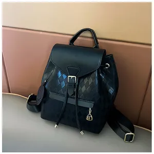 Detailed view of black quilted drawstring backpack with gold hardware and smiley charm