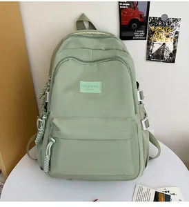 Detailed close-up of light green backpack with side buckle and fabric zipper pullers