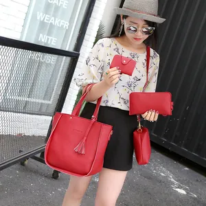 Red pebbled leather 4-piece handbag set featuring tote with tassel and crossbody bags