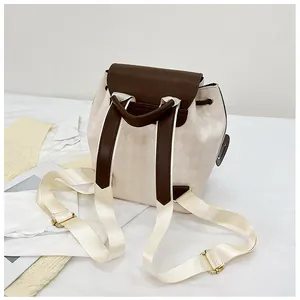 Detail of quilted drawstring bucket backpack with brown leather flap and gold hardware