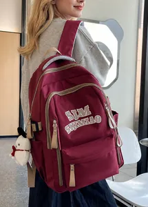 Detail view of burgundy high-capacity student backpack with multiple zipper pockets