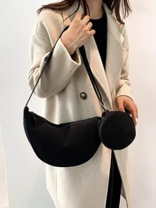 Minimalist black corduroy crescent bag with small round coin pouch and adjustable strap