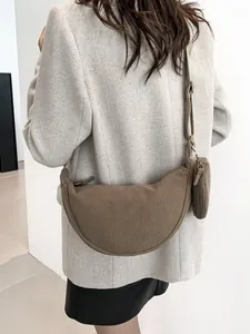 Minimalist dark brown corduroy crescent bag with small round pouch shown on model